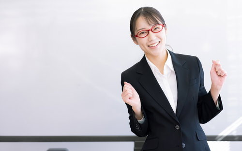 笑顔でガッツポーズをして応援するセミナー講師