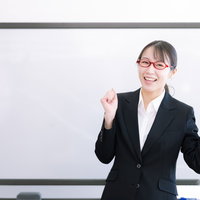 ガッツポーズで喜びを表現する女性講師の笑顔の写真