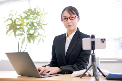 スマートフォンで動画配信をおこなうオンライン授業の女性講師