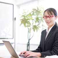 笑顔で声をかける女性講師とノートパソコンの写真