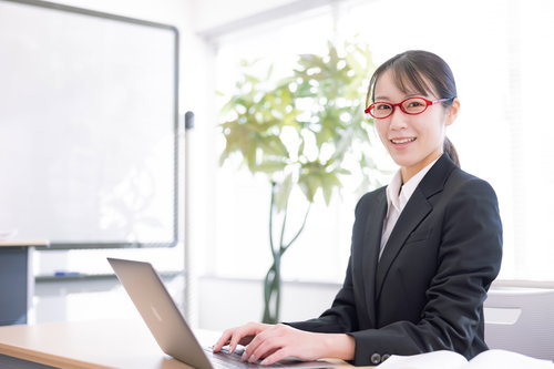 笑顔で声をかける女性講師とノートパソコン