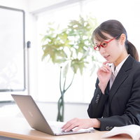 クライアントの要望を確認してプランを練る黒いスーツの女性ディレクターの写真