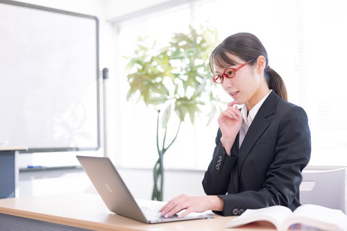 クライアントの要望を確認してプランを練る黒いスーツの女性ディレクター