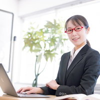 笑顔で対応するオフィスの受付女性秘書がセミナー対応の写真