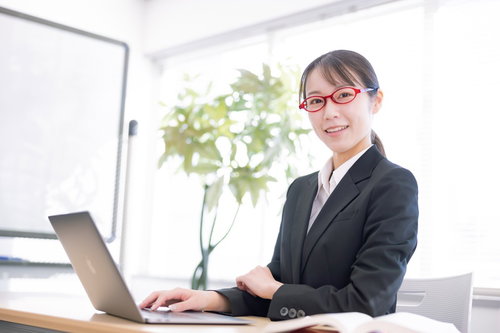 笑顔で対応するオフィスの受付女性秘書がセミナー対応