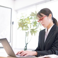 オフィスで研修中の課題に取り組む女性秘書の写真