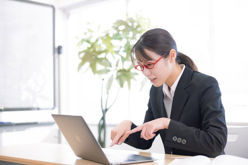 人差し指タイピングを矯正中の新人女性のデスクワーク