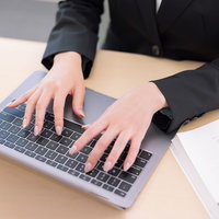 キーボードでタイピングする女性事務員の手元の写真