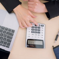 電卓で計算するデスクワーク中の女性の手元の写真