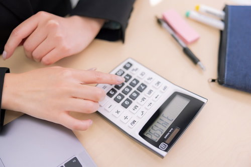 電卓を操作する女性の手元の