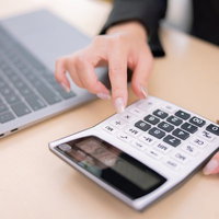 確定申告で電卓を使う事務員の指先の写真