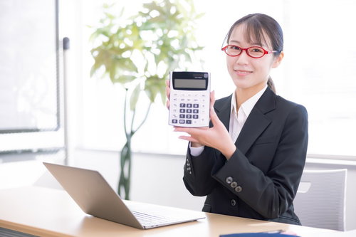 笑顔で電卓の商品説明をする女性社員