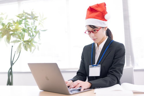 クリスマスの企画を真剣に考えるサンタ帽姿の女性社員