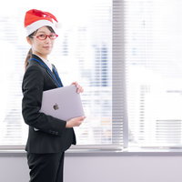 サンタ帽をかぶったクリスマスモードの女性社員の写真