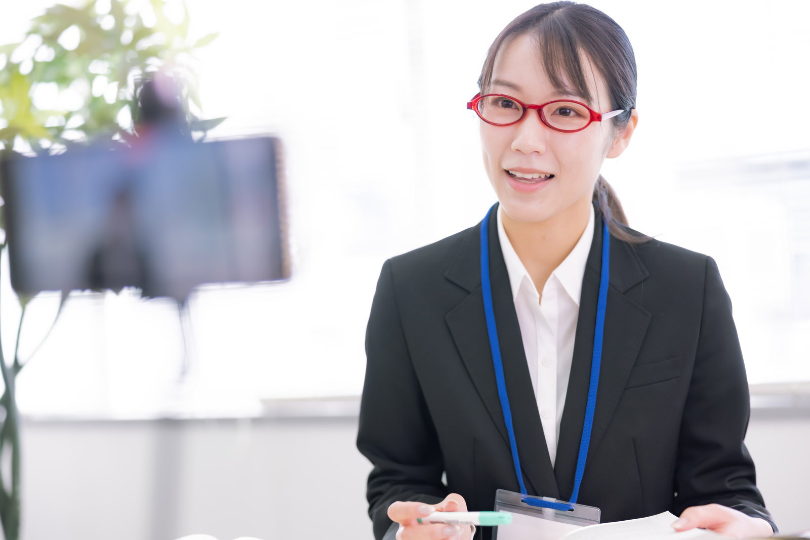 スーツ姿で眼鏡をかけた女性指導員がオンライン講義を行っている［モデル：SAKI］