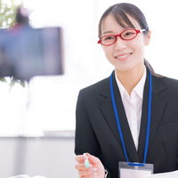 笑顔で画面に向かってオンライン講義する女性講師の写真