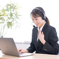 黒いスーツを着て懇切丁寧にコール業務する女性の写真