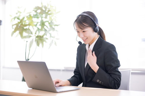 黒いスーツを着て懇切丁寧にコール業務する女性