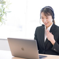 まごころ丁寧にテレアポする黒いスーツの女性オペレーターの写真