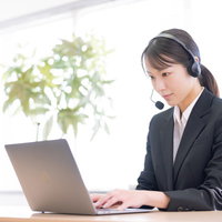 ヘッドセットを装着して対応するオペレーター業務の女性の写真