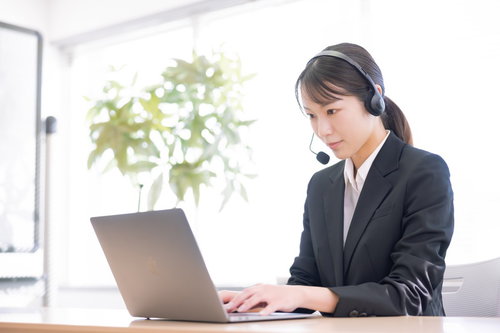 ヘッドセットを装着して対応するオペレーター業務の女性