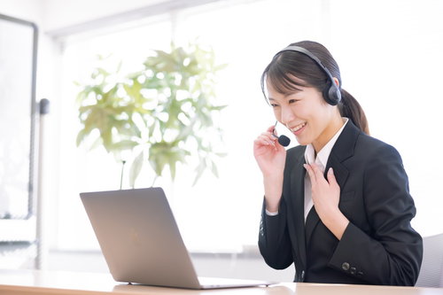 胸に手を当てて対応するコールセンターの女性オペレーター