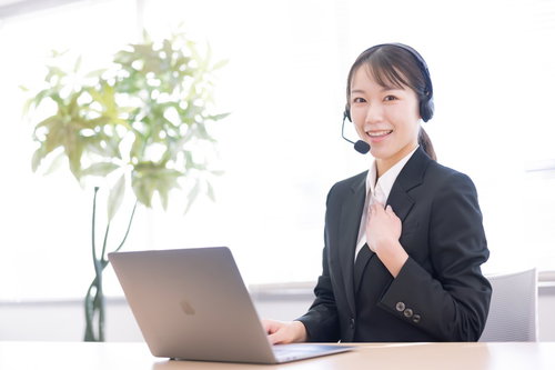 手を胸に当てて笑顔のコールセンターの女性オペレーター