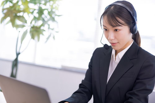 ヘッドセットを着けて真剣な眼差しで業務をこなす女性オペレーター