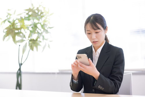 スマホ操作に困惑する女性会社員