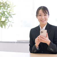 スマホ操作を教えるショップ店員の笑顔と顧客対応の写真