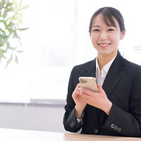 携帯ショップ店員の接客風景でスマートフォンを案内する女性の写真