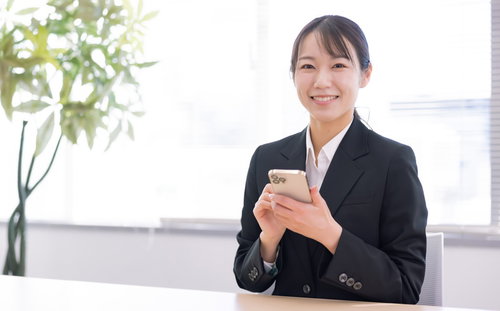 携帯ショップ店員の接客風景でスマートフォンを案内する女性