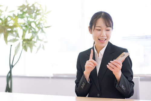 スマートフォンの操作を案内する笑顔の女性