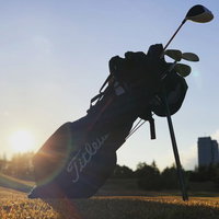 夕暮れのゴルフ場に置かれたゴルフバッグのシルエットの写真