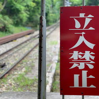 線路脇に設置された赤い立入禁止の警告看板の写真