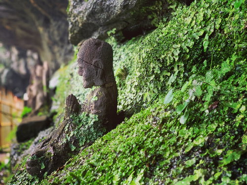 山に潜む苔むした古いお地蔵さんの石像と自然が織りなす風景