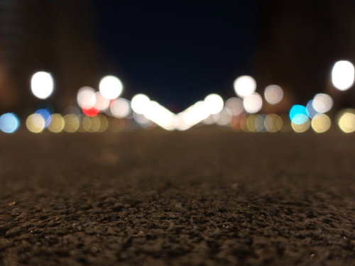 夜の石畳に映るボケた街灯の光と地面の温かみ