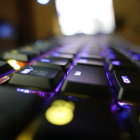 紫と青に光るゲーミングキーボード、高速入力対応の写真