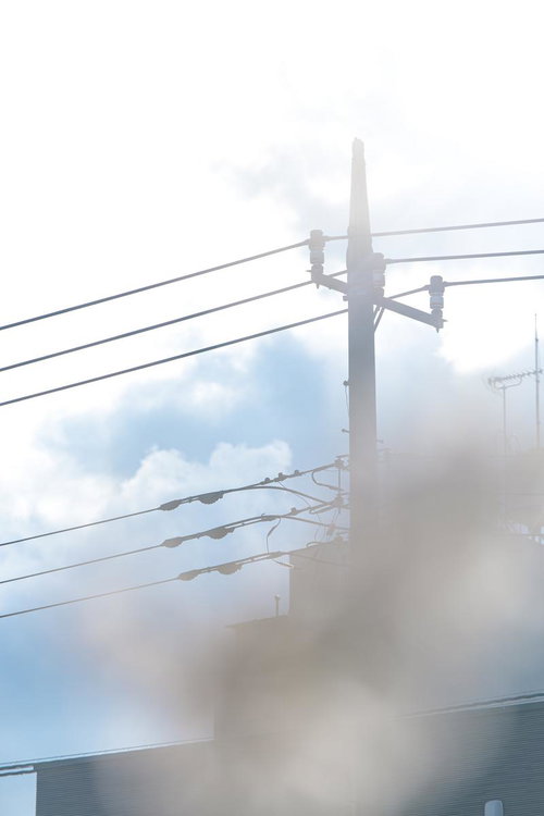 霧の中に立つ電柱と電線の風景