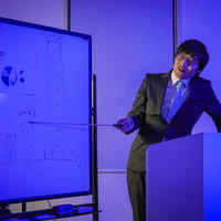 ブルーライト・ヨコカラ プレゼンで資料を説明する男性の写真