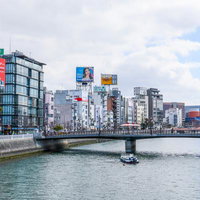 福岡の中洲を流れる那珂川にかかる橋と高層ビル群の街並みの写真