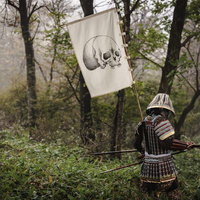 黒い甲冑に身を包み骸骨の指物を背負う武士の写真