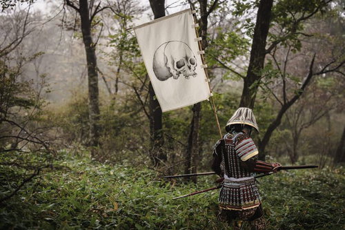 黒い甲冑に身を包み骸骨の指物を背負う武士