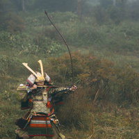 霧の野原で大弓を引く鎧姿の侍が矢を放つ瞬間の写真