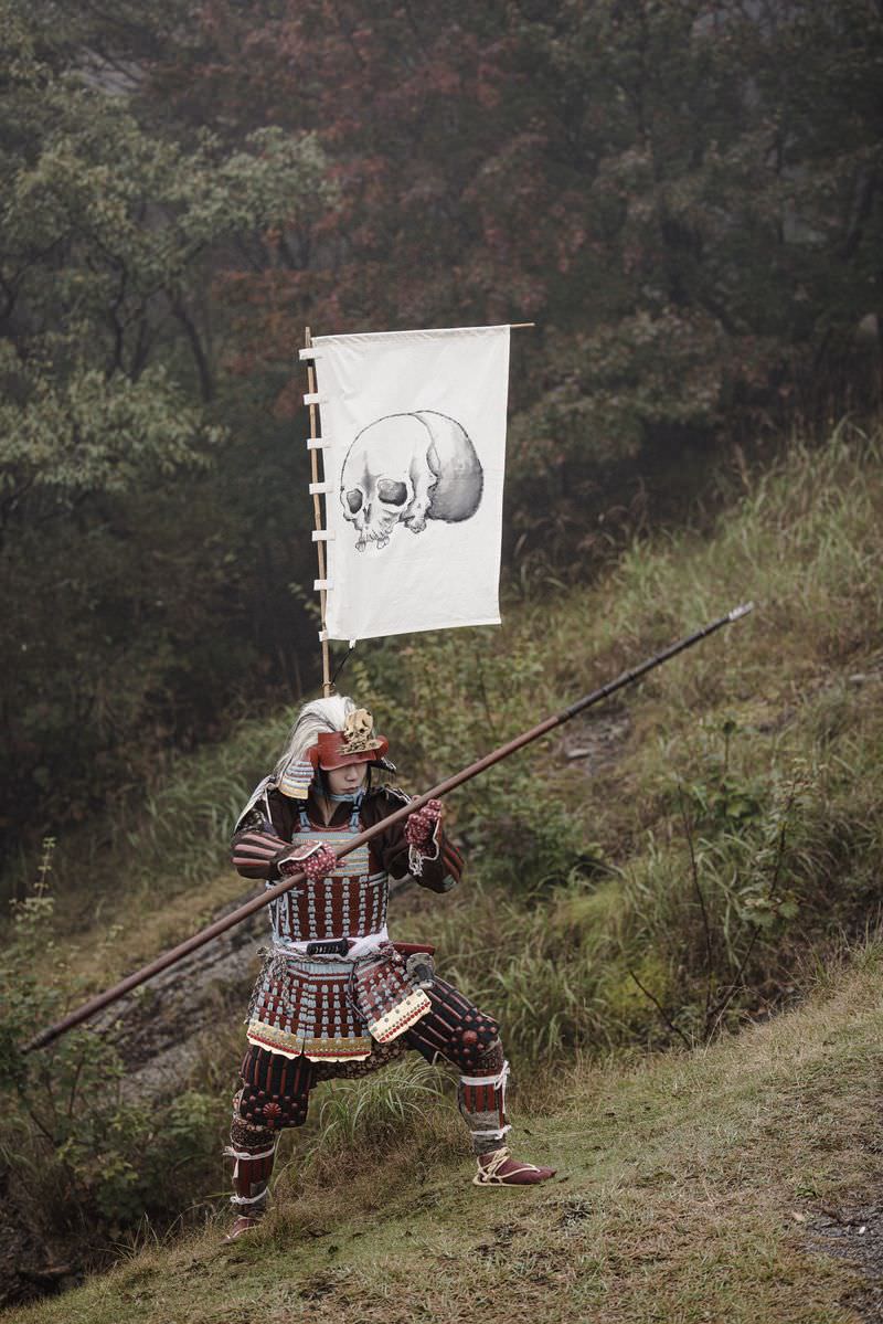 甲冑を身に着けた武士が槍を構えて立つ姿［モデル：まーこ］