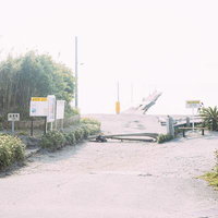原岡桟橋への入口となる砂利道と駐車場、道標の写真