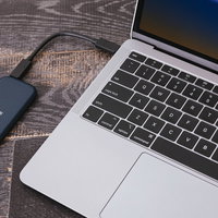コンパクトなポータブルSSDをMacBookに接続するバックアップの写真