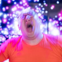 ゲーミング赤血球でサイリウムを振るオタク男性の写真