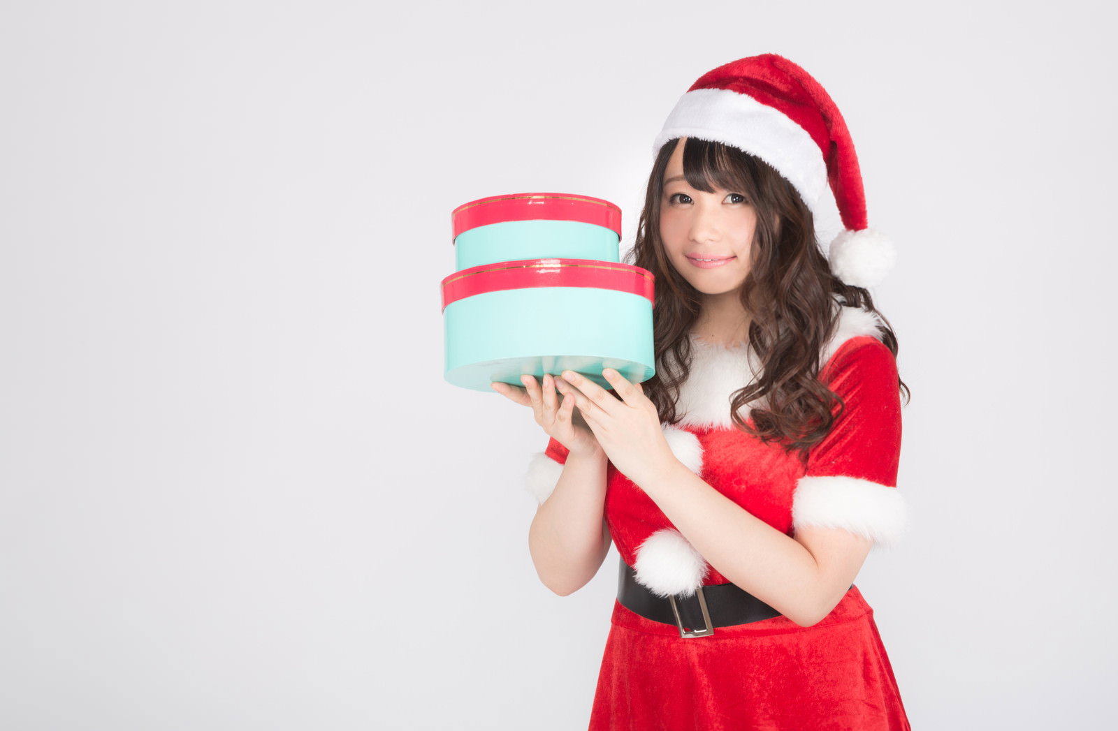 プレゼント箱を持ったサンタコスプレの女性［モデル：茜さや］