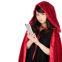 赤いもこもこマントに仮装した女性がiPhoneを手にした姿の写真